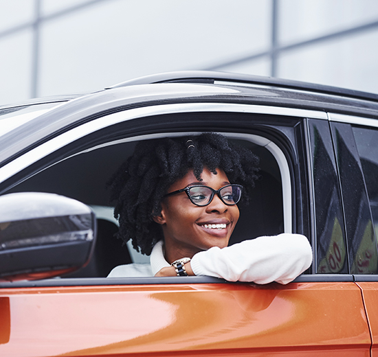 Eine Frau mit einer Brille sitzt in einem Auto.