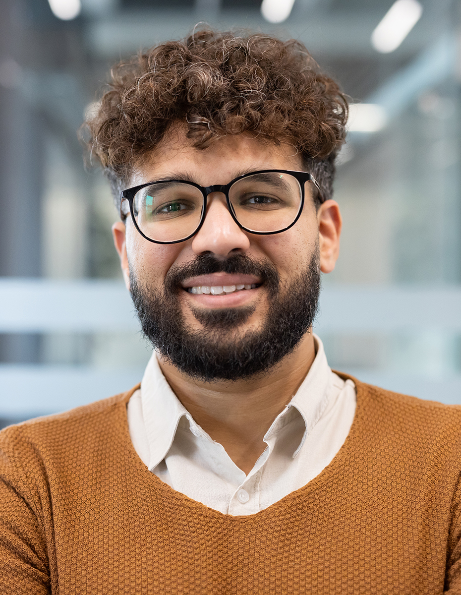 Eine Person mit einer Brille und einer runden Gesichtsform.