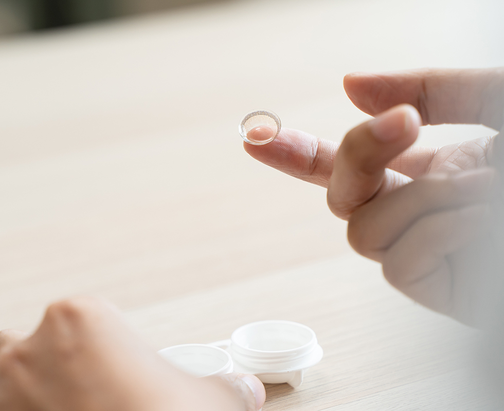 Eine Person hat eine Kontaktlinse auf dem Finger.