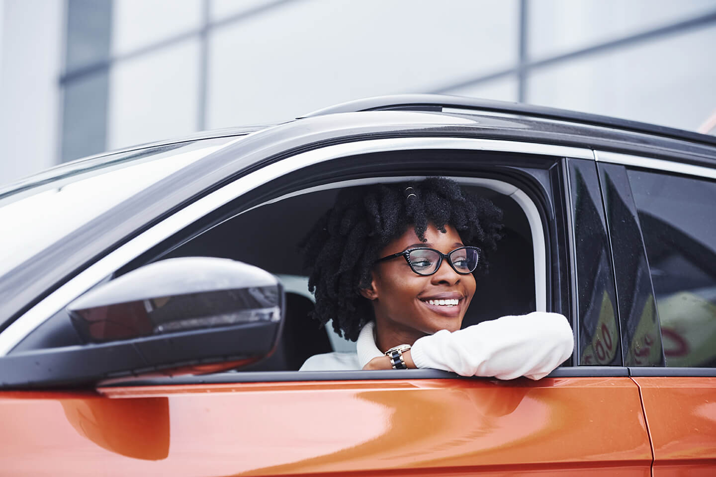 Eine Frau mit einer Brille sitzt in einem Auto.